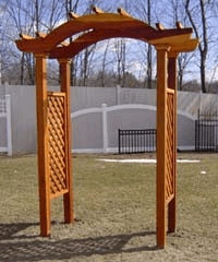 A wooden archway is sitting in the middle of a grassy field.