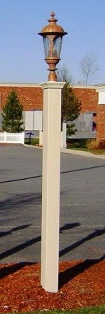 A white pole with a lamp on top of it in a parking lot.