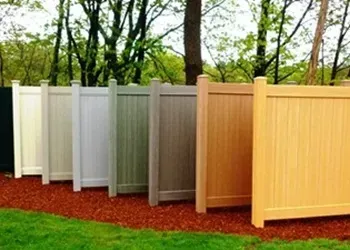A row of fences of different colors are lined up in a yard.