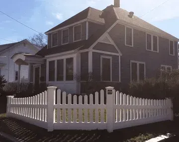 A house with a white picket fence in front of it