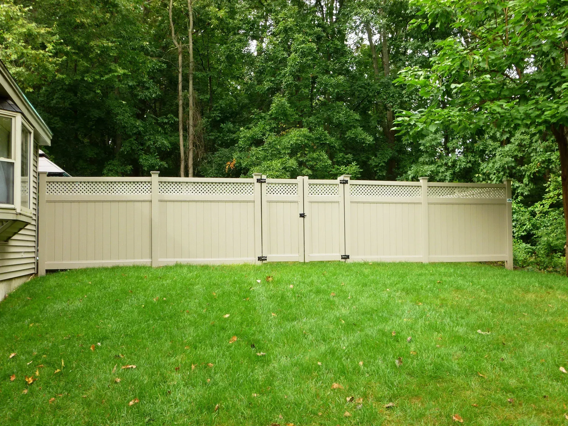 There is a fence and a gate in the backyard.