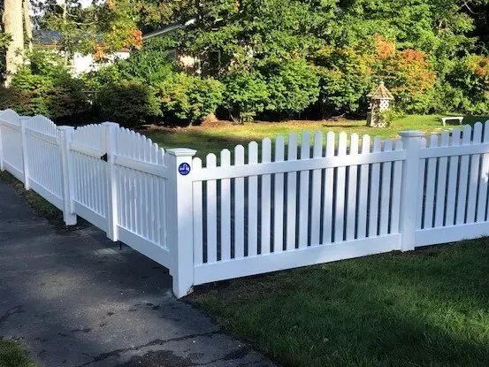 A white picket fence surrounds a lush green yard.