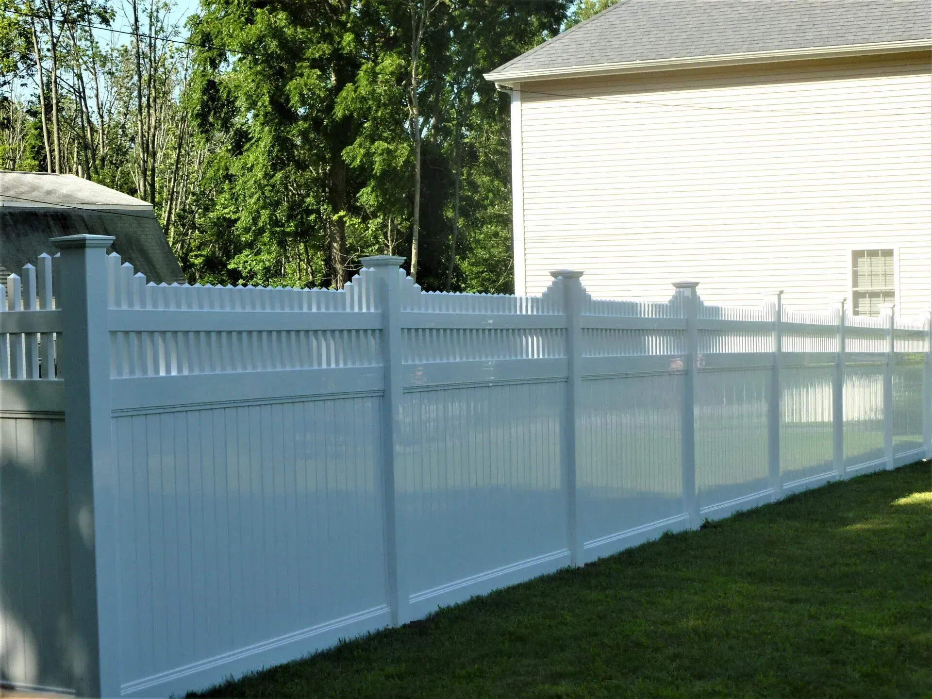 A white fence with a house in the background