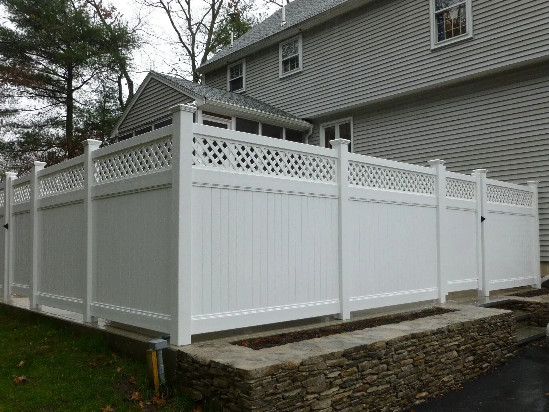 A white fence is sitting in front of a house.