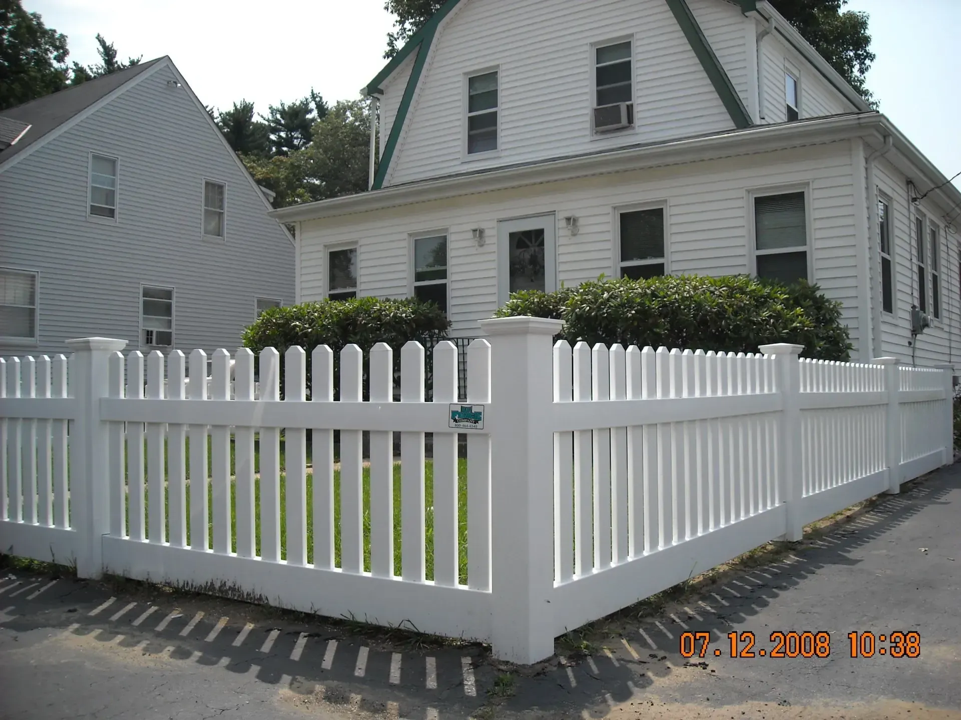 A white house with a white picket fence in front of it