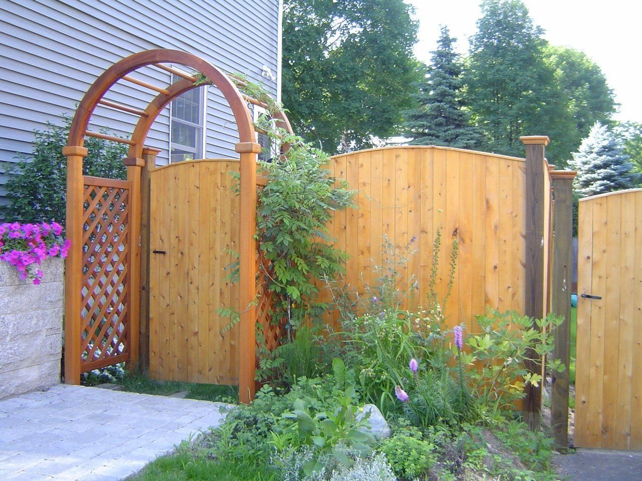 A wooden fence with a wooden arch and gate