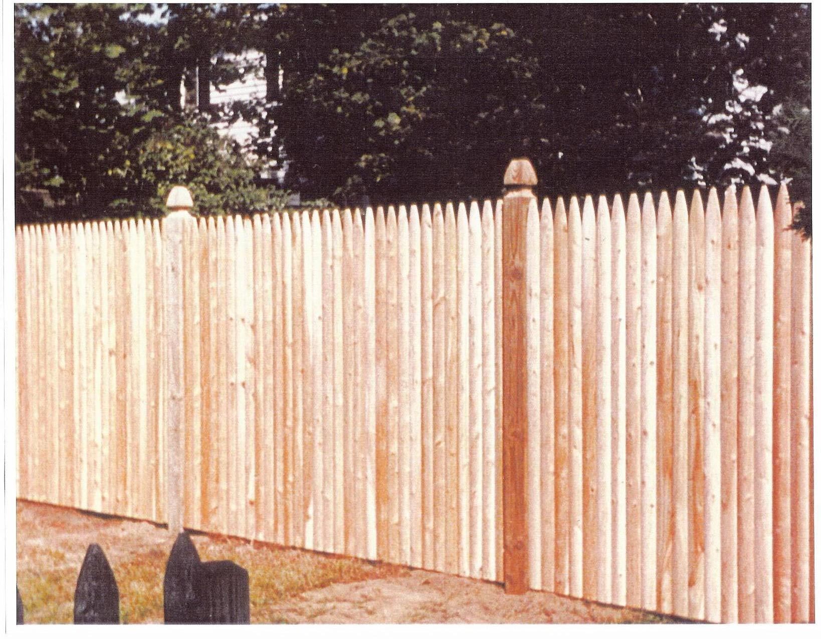 A picture of a wooden fence with trees in the background
