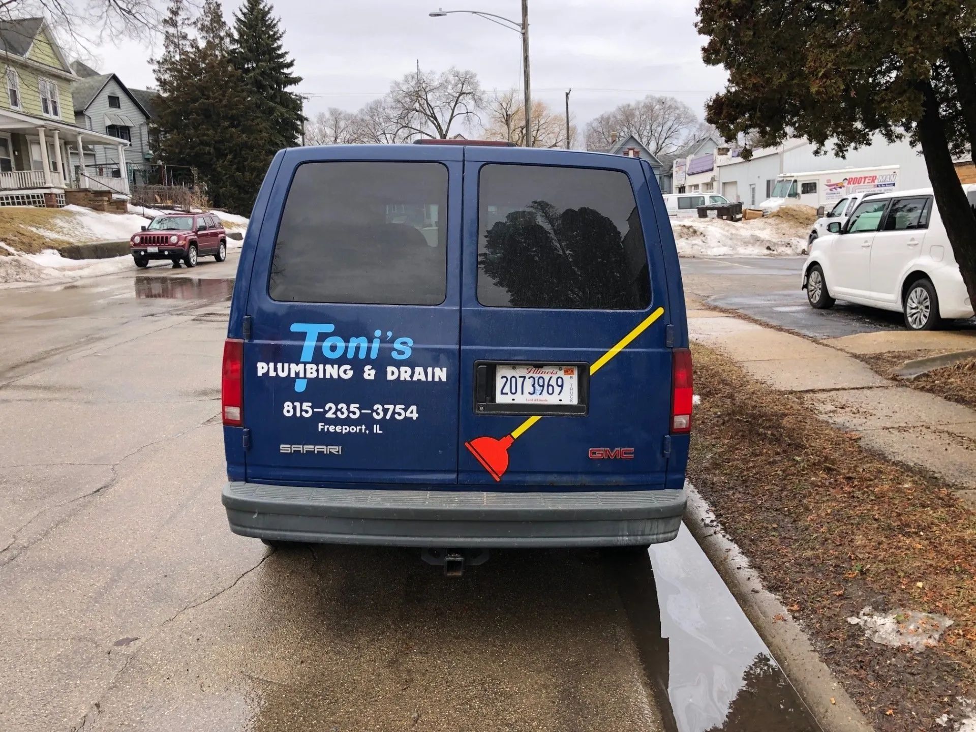 Blue Toni's Plumbing & Drain van parked on a street with snow.