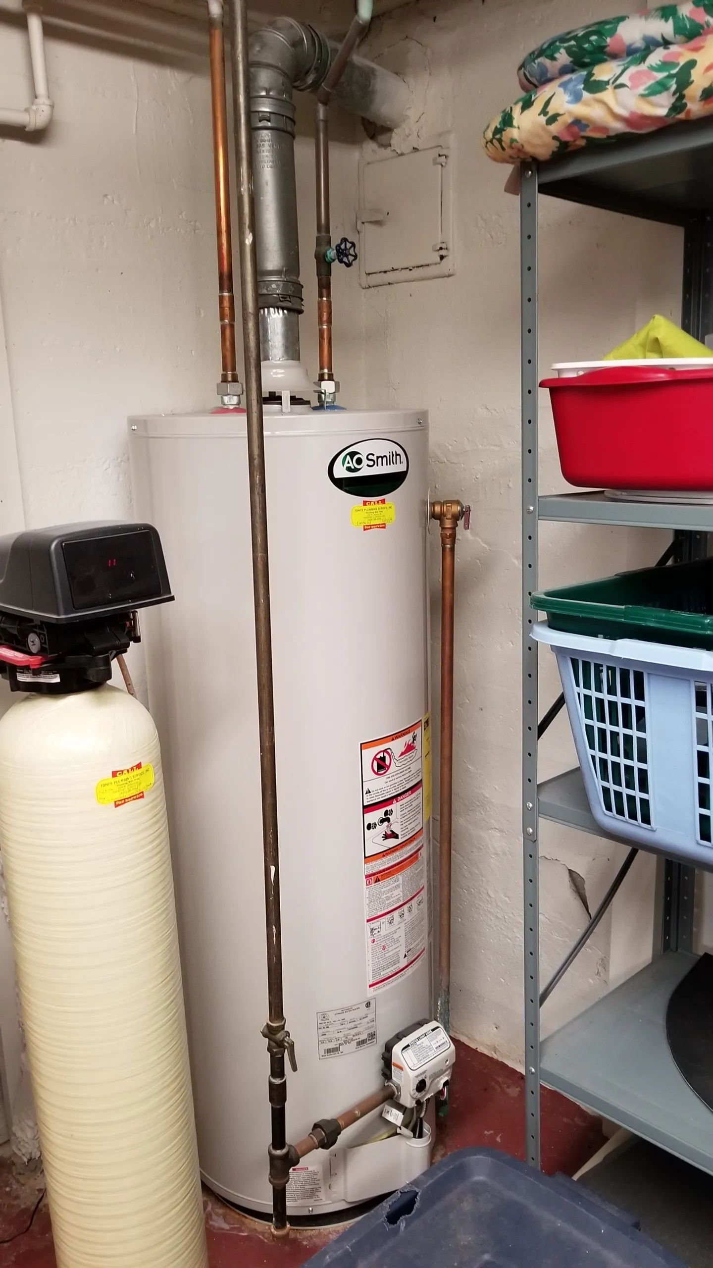 Water heater and water softener in a basement storage area.