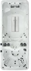 Overhead view of a rectangular, light-colored swim spa with jets and seating.