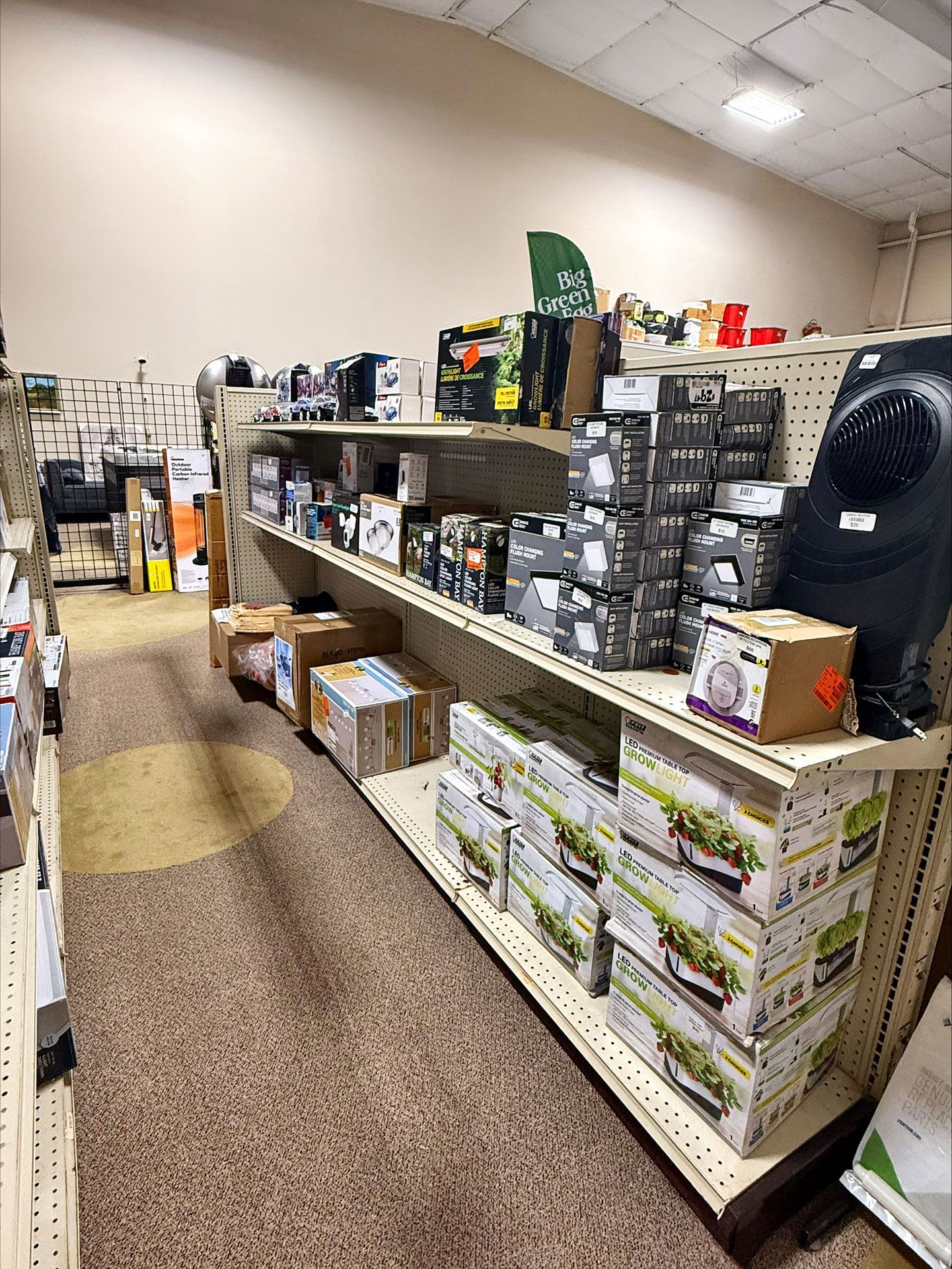 Shelves stocked with various store products; neutral-toned walls, speckled floor.