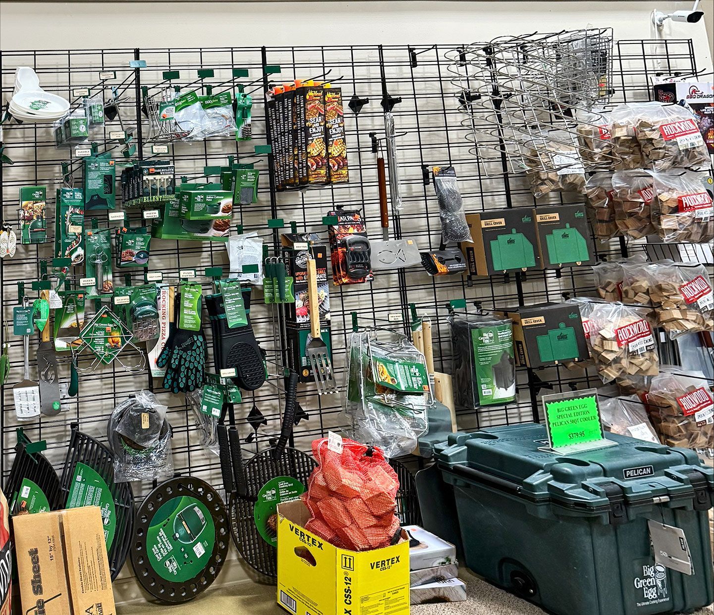 Wall display in a store, green and black gardening tools, and containers with products.
