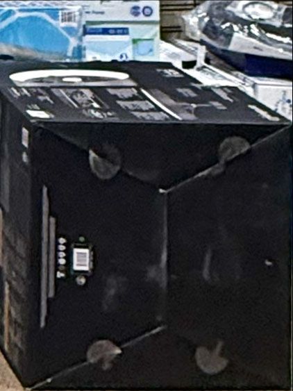 Black cardboard box, possibly a product package, with a QR code and product info visible.