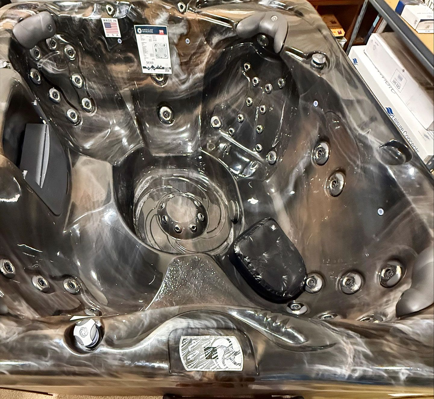 Dark gray hot tub with multiple jets and seating areas.