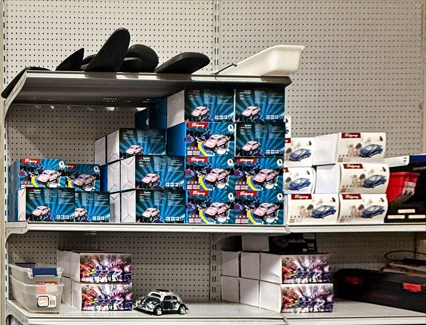 Shelves stacked with various toy car boxes in blue, white, and red.
