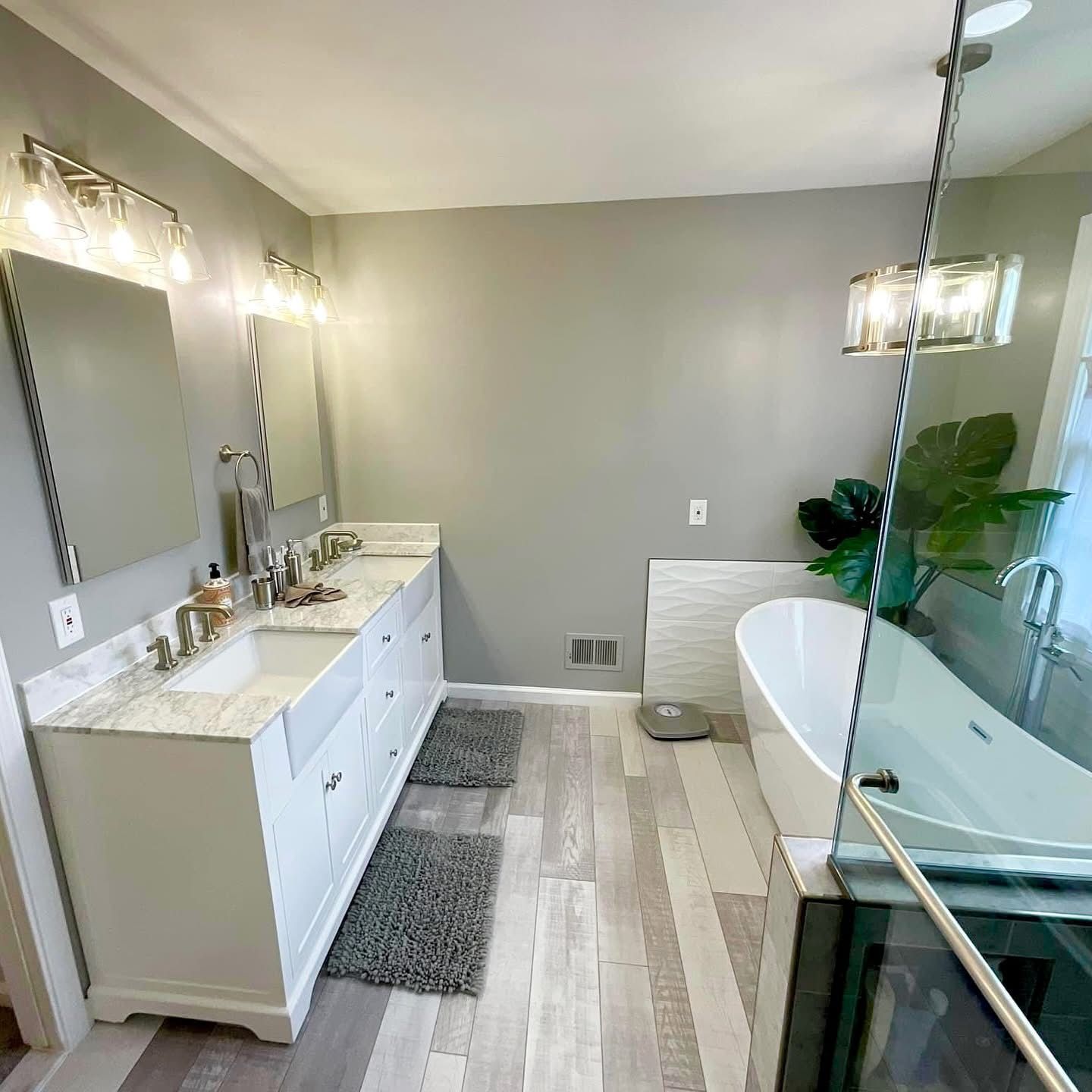 Bright modern bathroom with double vanity, glass shower, and freestanding tub