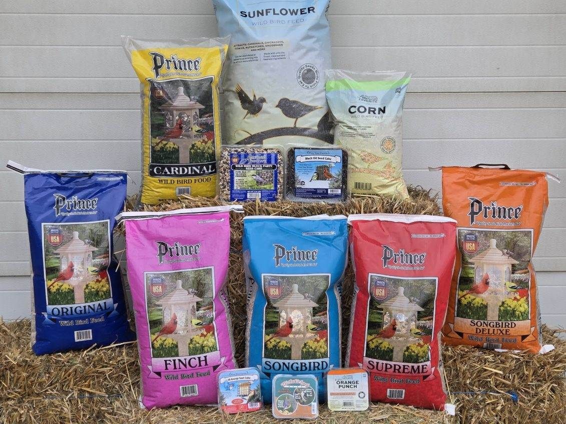 A bunch of bags of food are sitting on top of a pile of hay