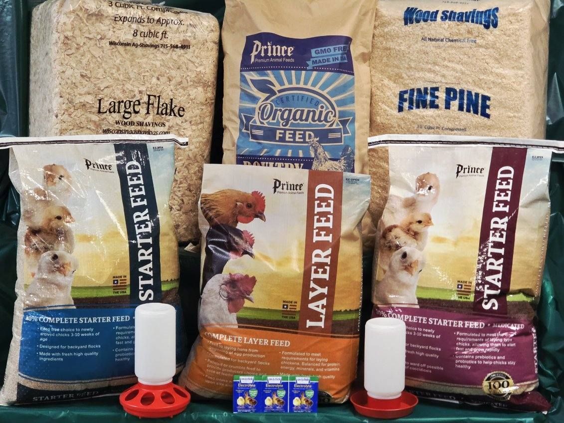 A bunch of bags of chicken food are sitting on a table