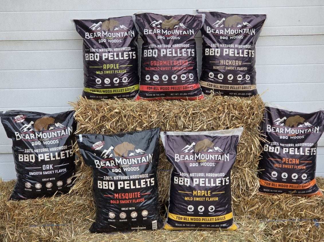 A bunch of bags of dog food are sitting on top of a pile of hay