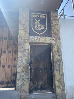 A stone building with a wooden door and a sign that says god 's army.