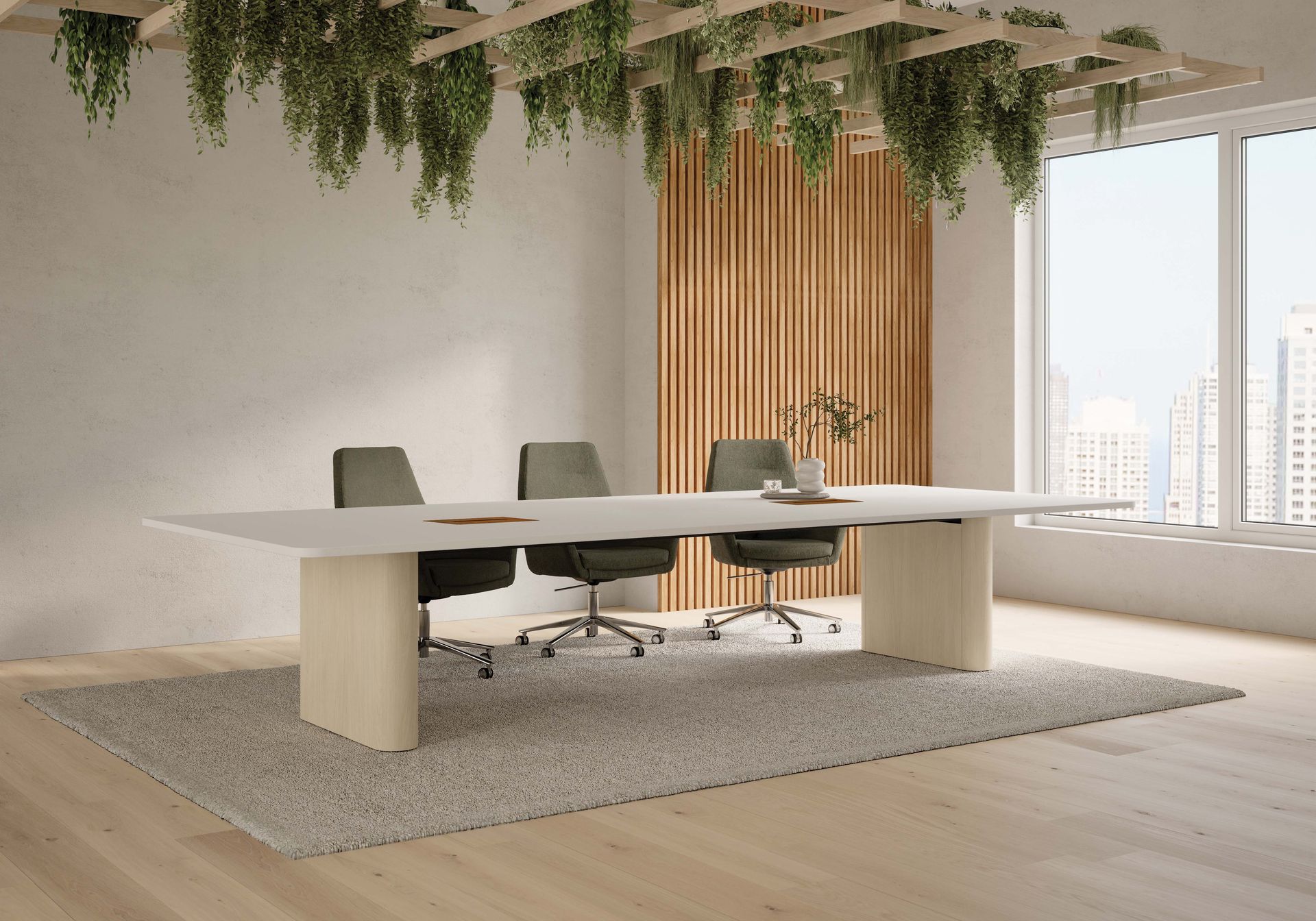 Modern conference room with long white table, gray chairs, hanging greenery, and large windows.