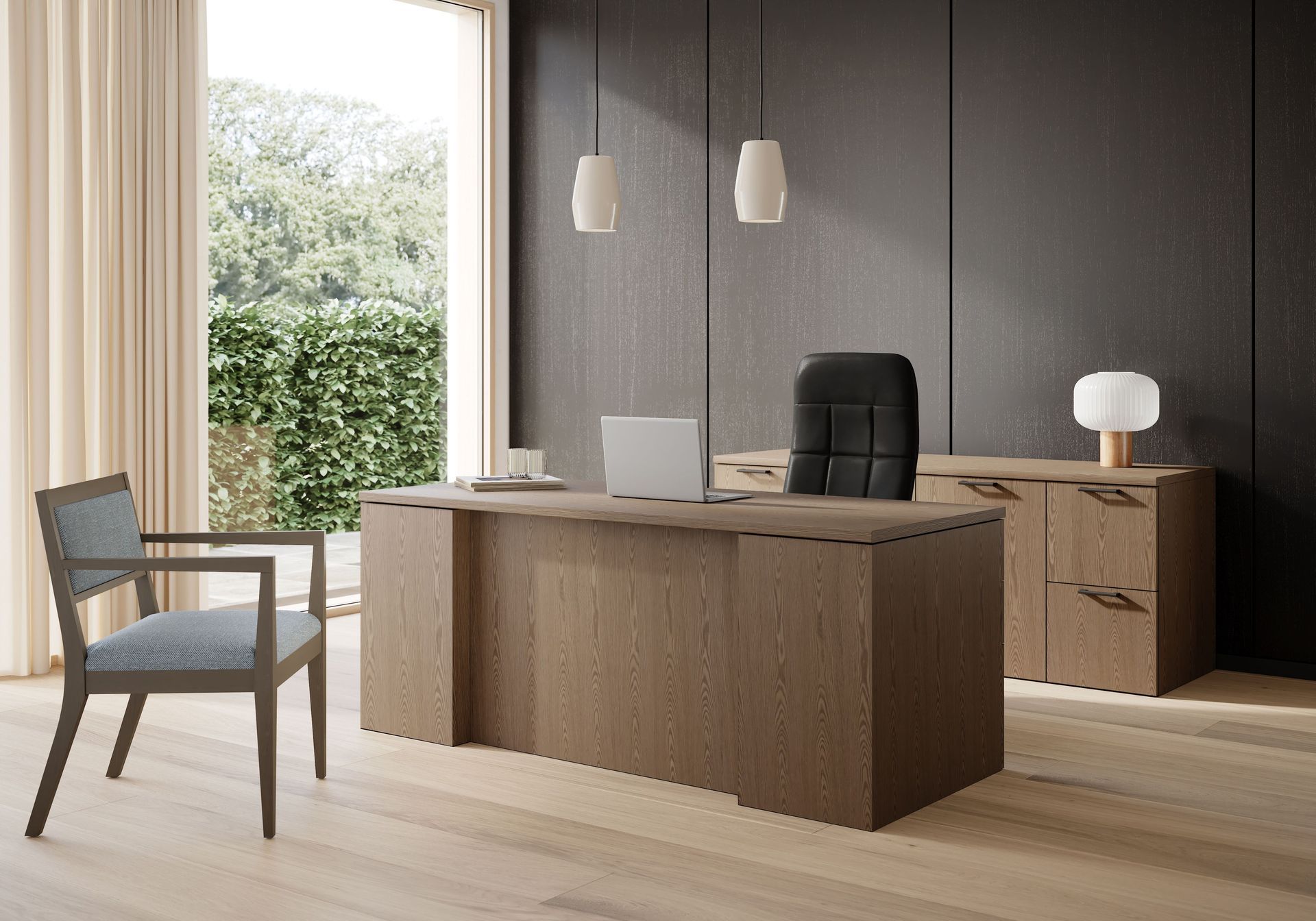 Modern office with wooden desk, black chair, side cabinet, and chair by a bright window