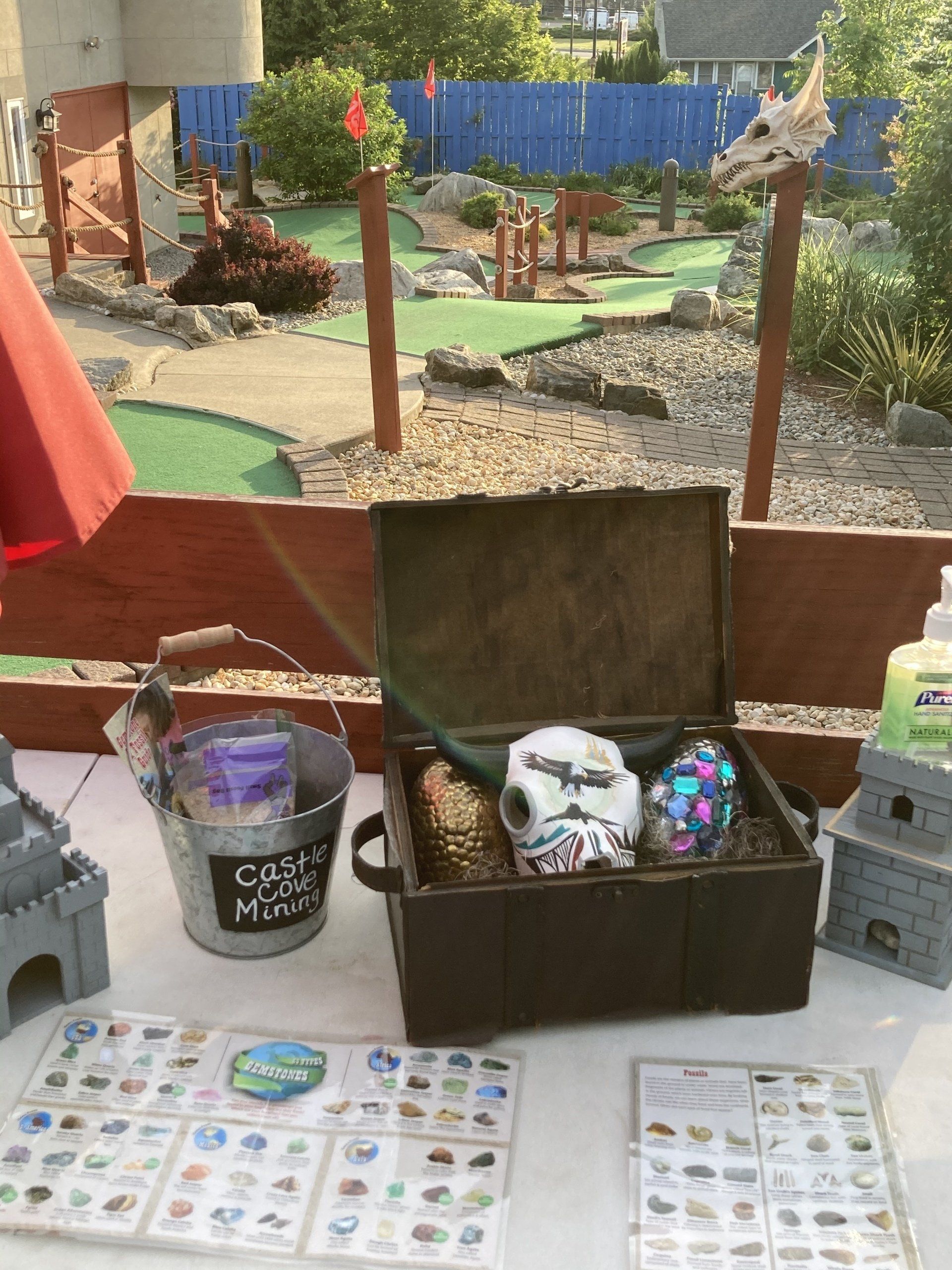 A table with a trunk filled with toys and a bucket that says castle magic on it.