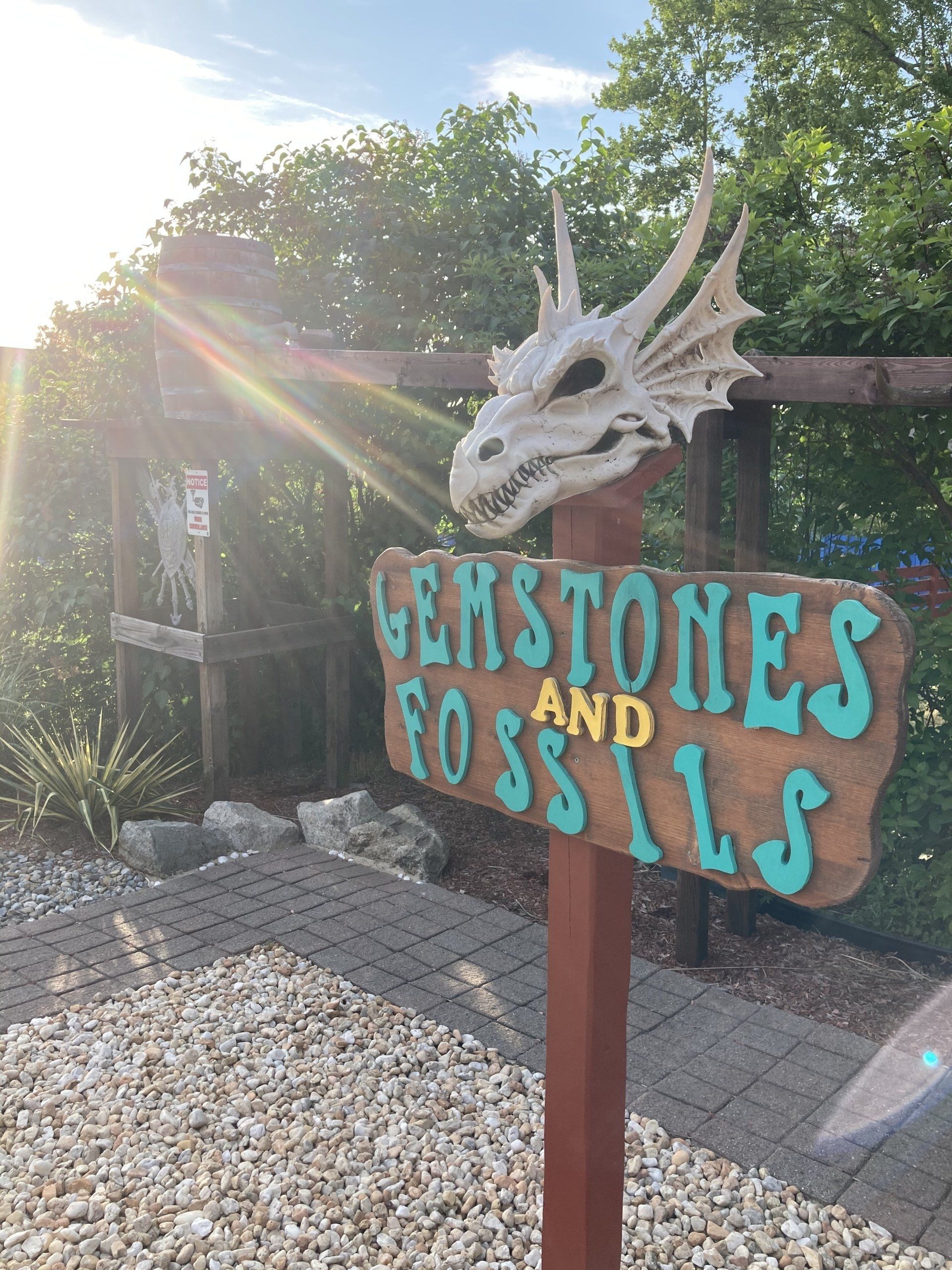 A sign that says ' gems stones and fossils ' on it