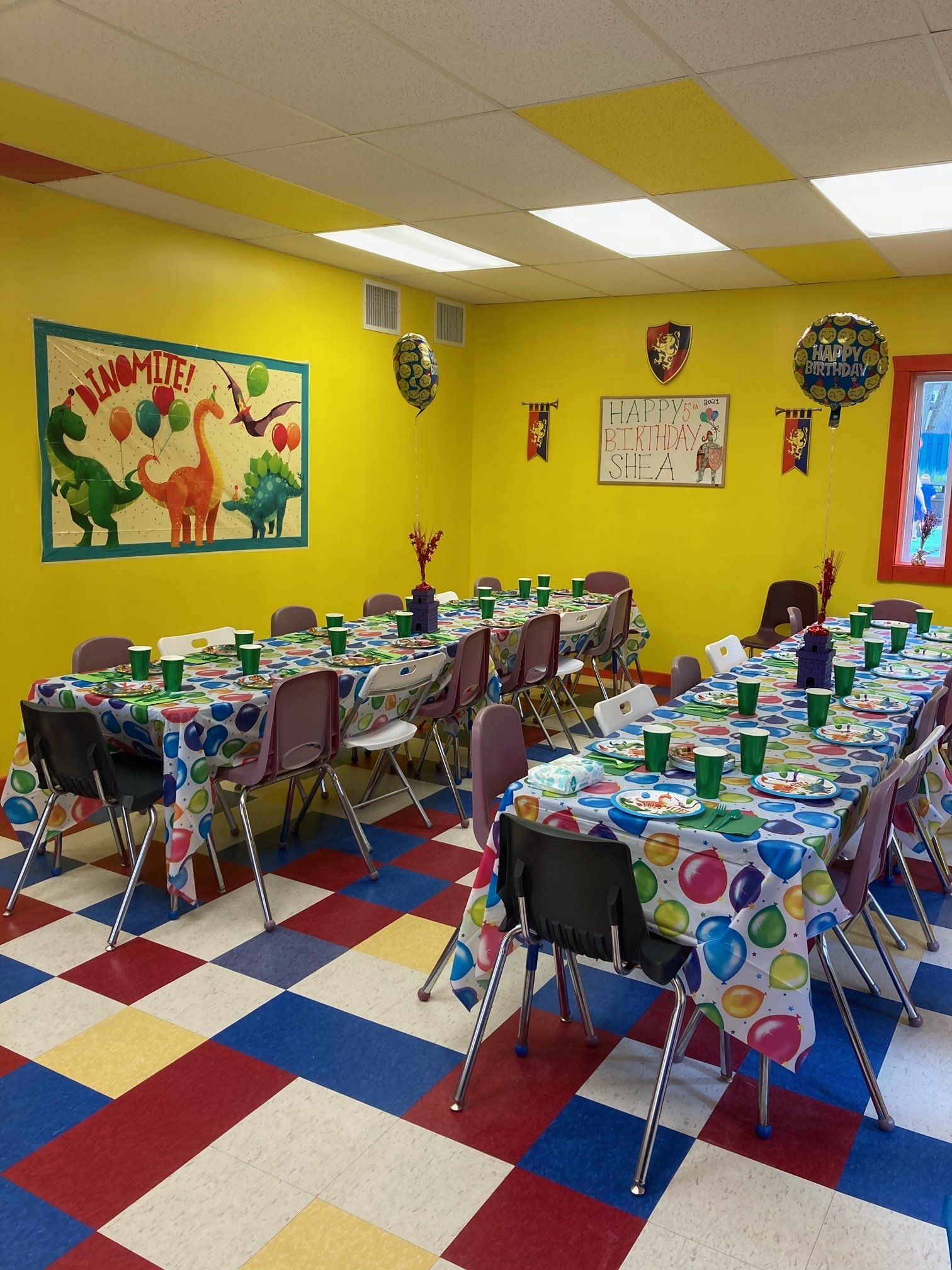A room with tables and chairs set up for a birthday party