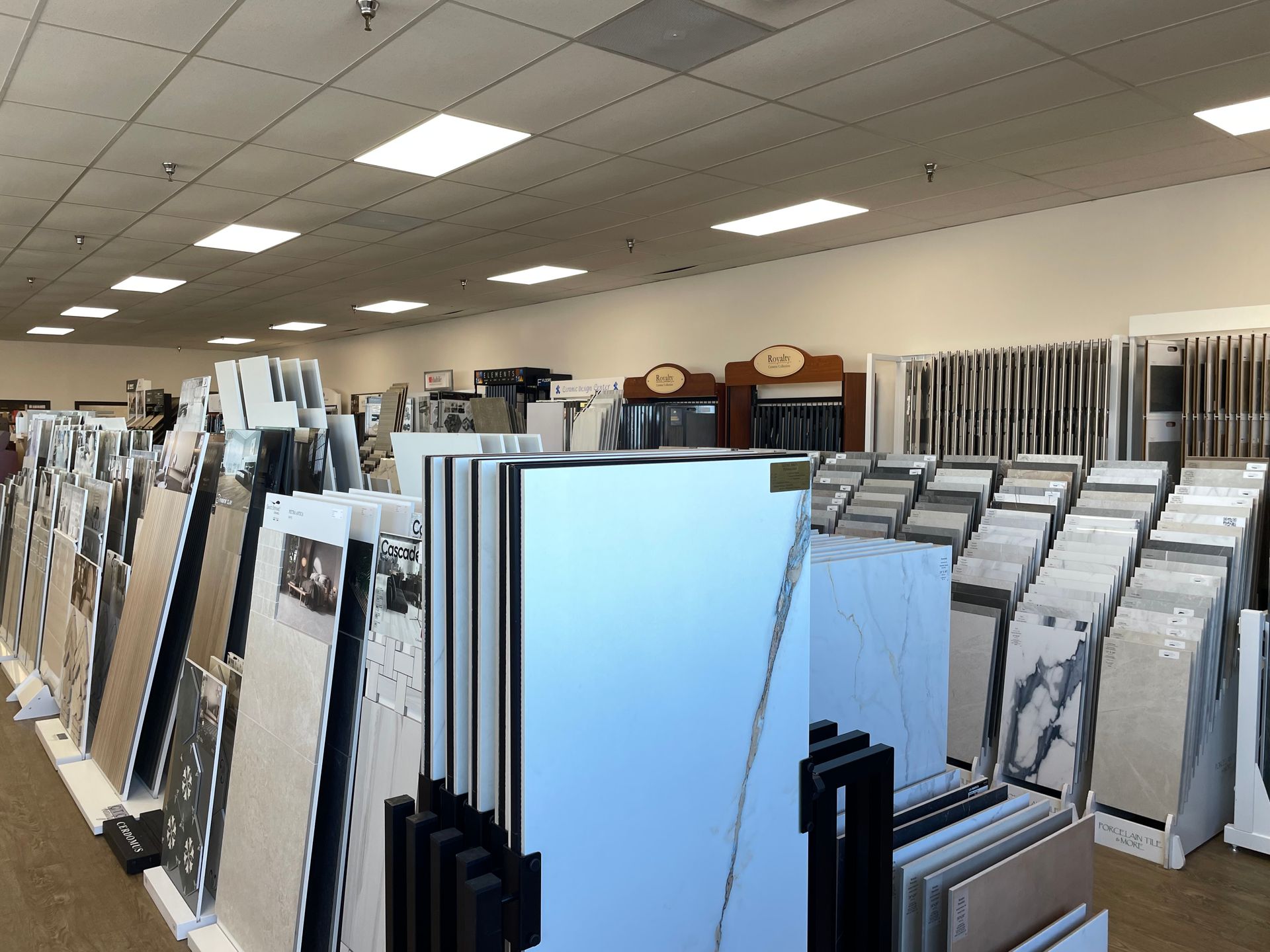 A large room filled with lots of tiles on display in a tile store.