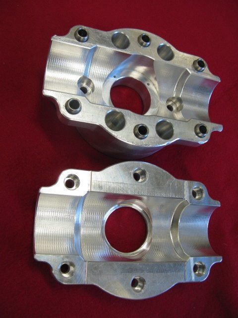 Two pieces of metal with holes in them on a red surface