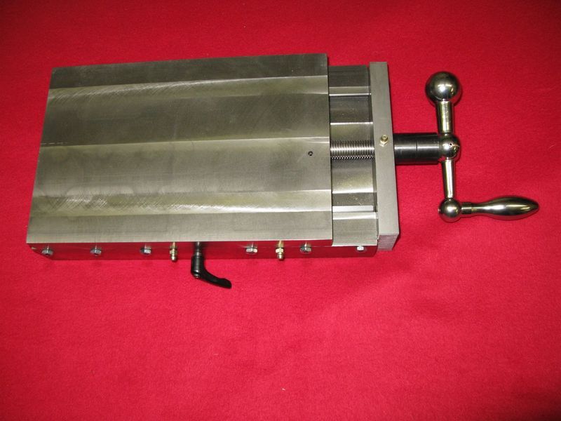 A metal object with a handle is sitting on a red surface