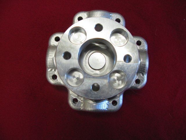 A metal object with holes in it is on a red surface