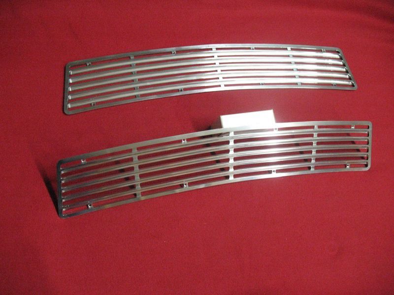 A pair of stainless steel grilles on a red surface