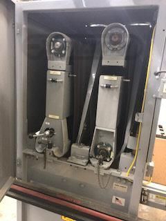 A machine is sitting inside of a cabinet with the door open.