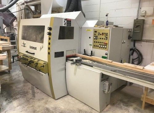 A large machine is sitting in a woodworking shop.