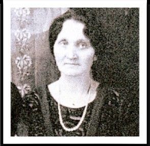 A black and white photo of a woman wearing a pearl necklace.