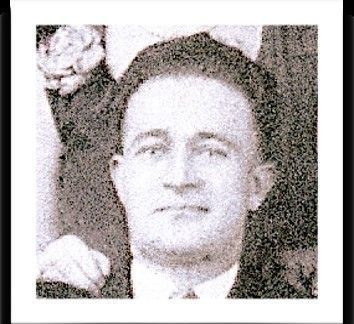 A black and white photo of a man in a suit and tie