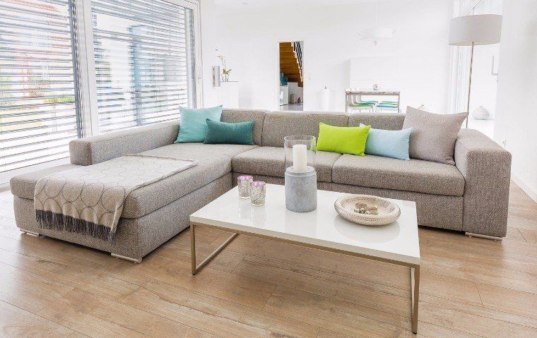 A living room with a large sectional couch and a coffee table.