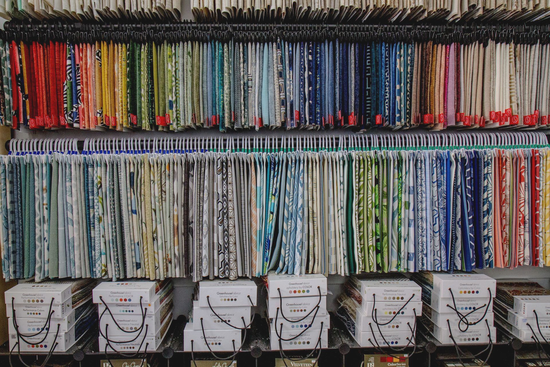 A shelf filled with lots of different colored fabrics