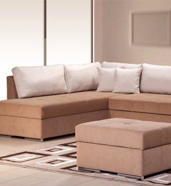 A living room with a sectional couch and an ottoman