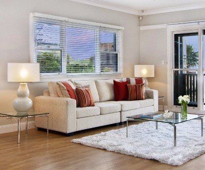 A living room with a white couch and a glass coffee table