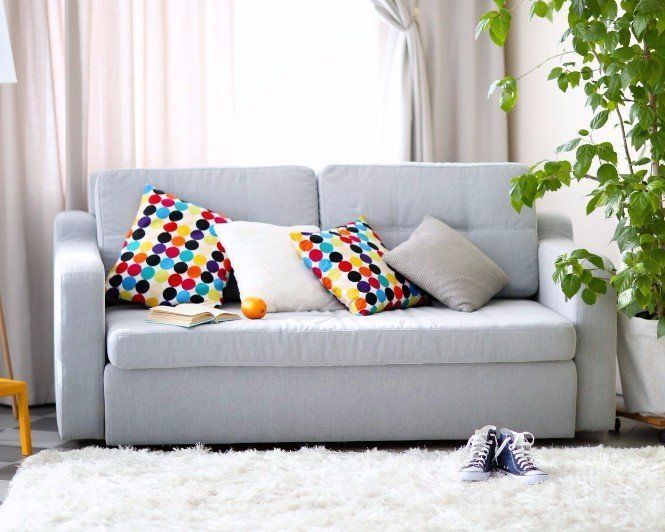 A living room with a white couch and colorful pillows