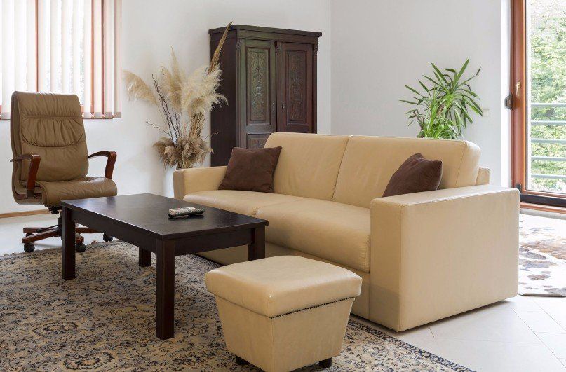 A living room with a couch ottoman coffee table and chair