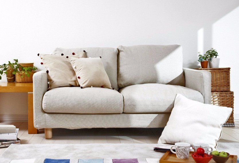 A living room with a white couch and pillows