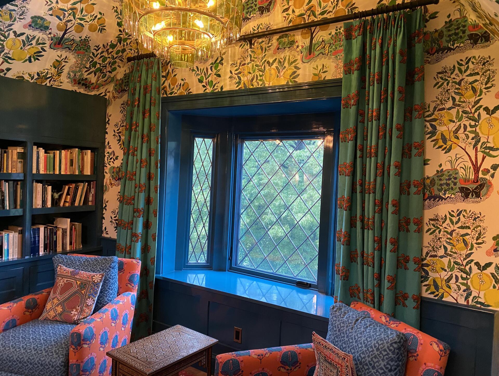 A living room with two chairs , a table , and a window.