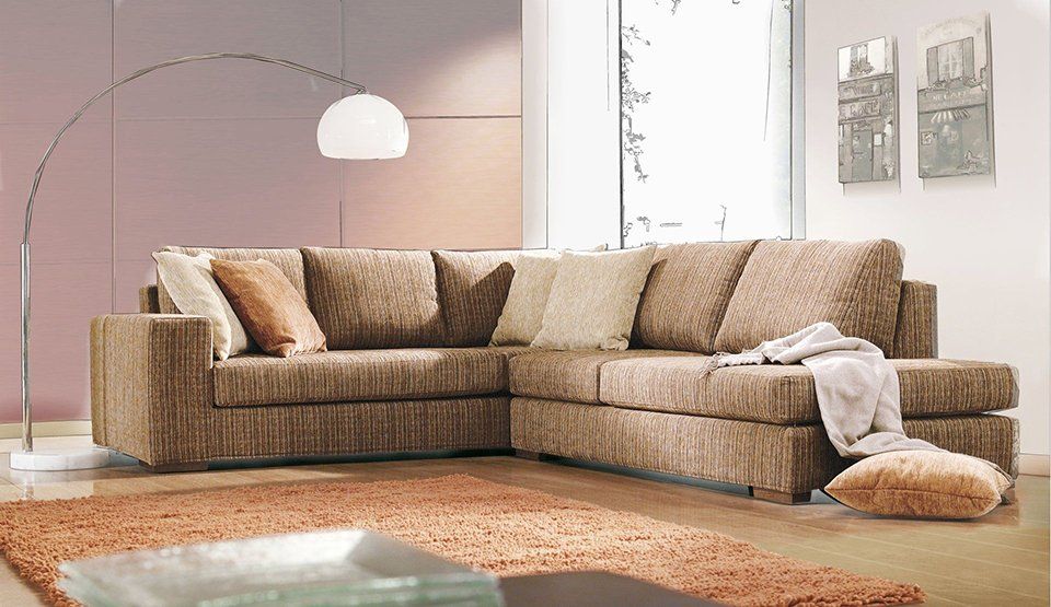 A living room with a sectional couch and a rug