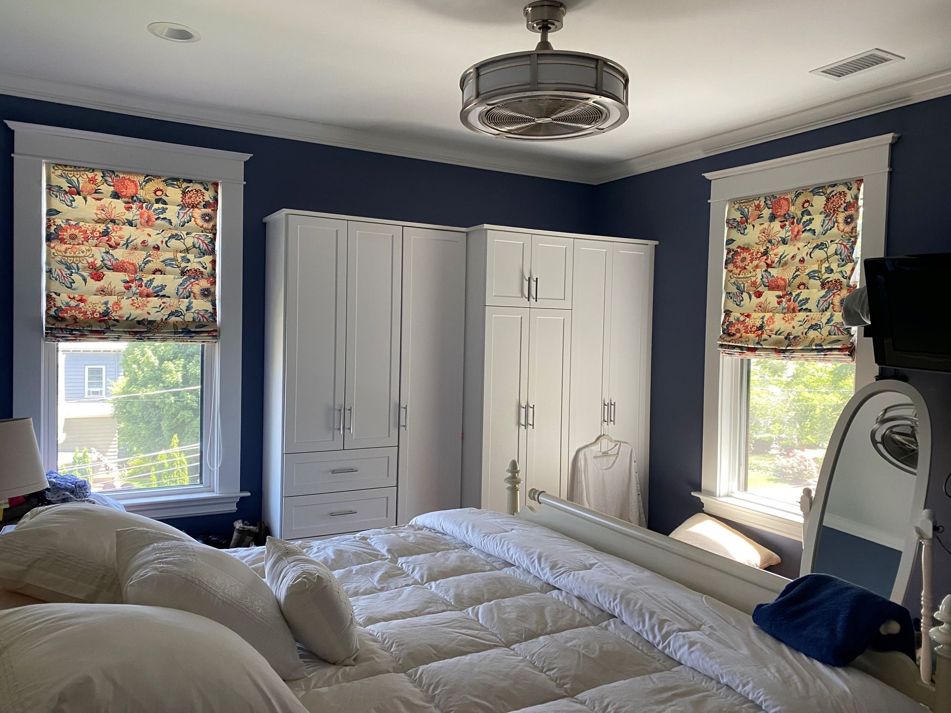 A bedroom with a large bed and a ceiling fan