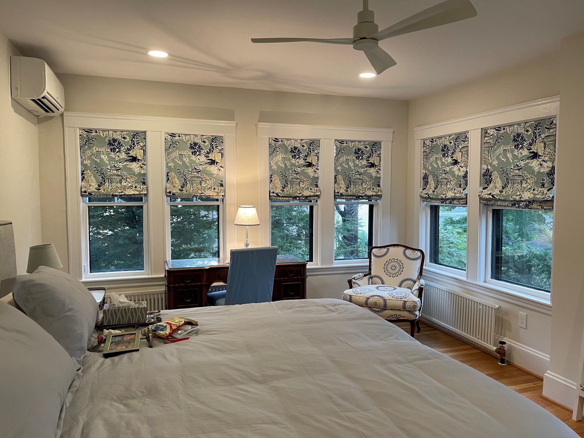 A bedroom with a large bed and a ceiling fan