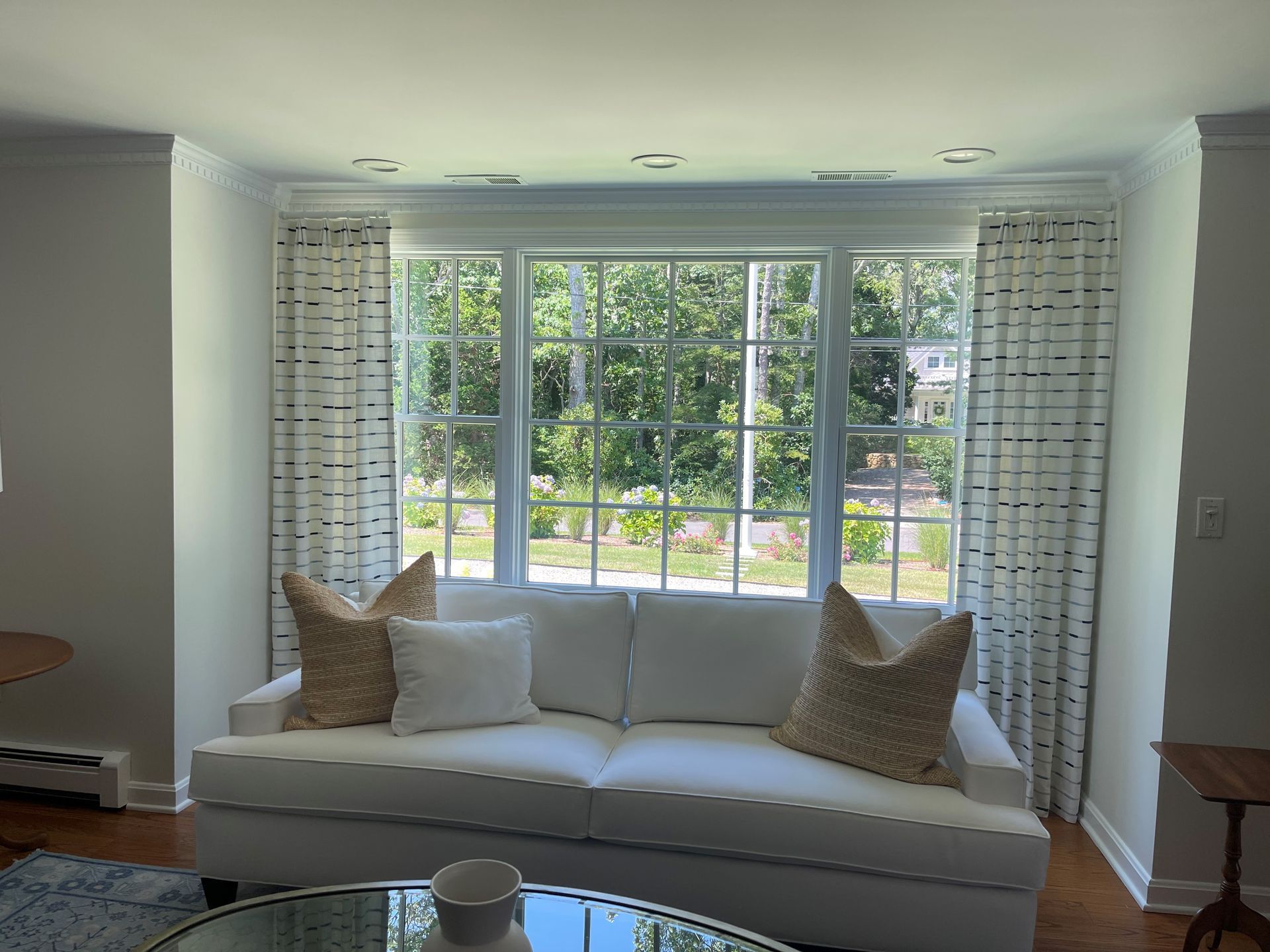 A living room with a white couch and a large window.